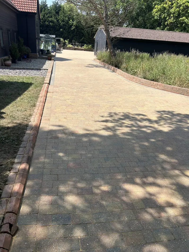 Long block-paved driveway with lawn to the left