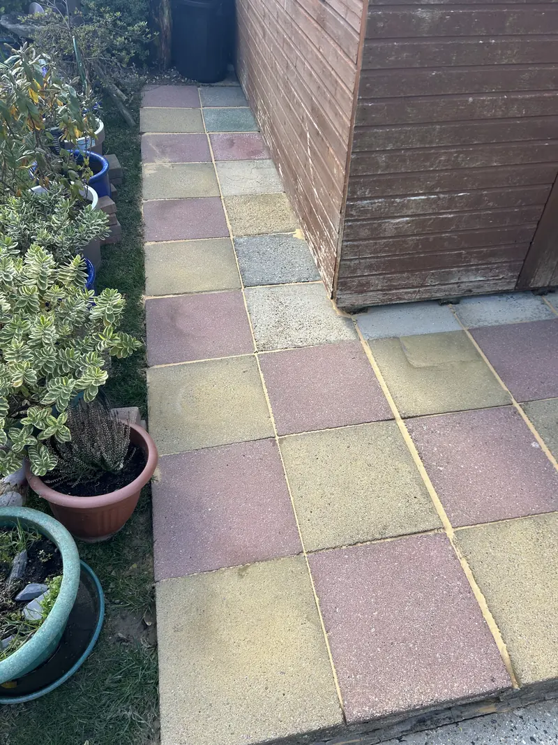 Yellow and red chequered slab path beside a shed