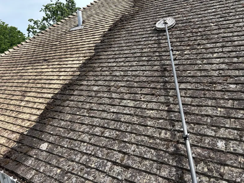 Soft wash lance working across a mossy tiled roof