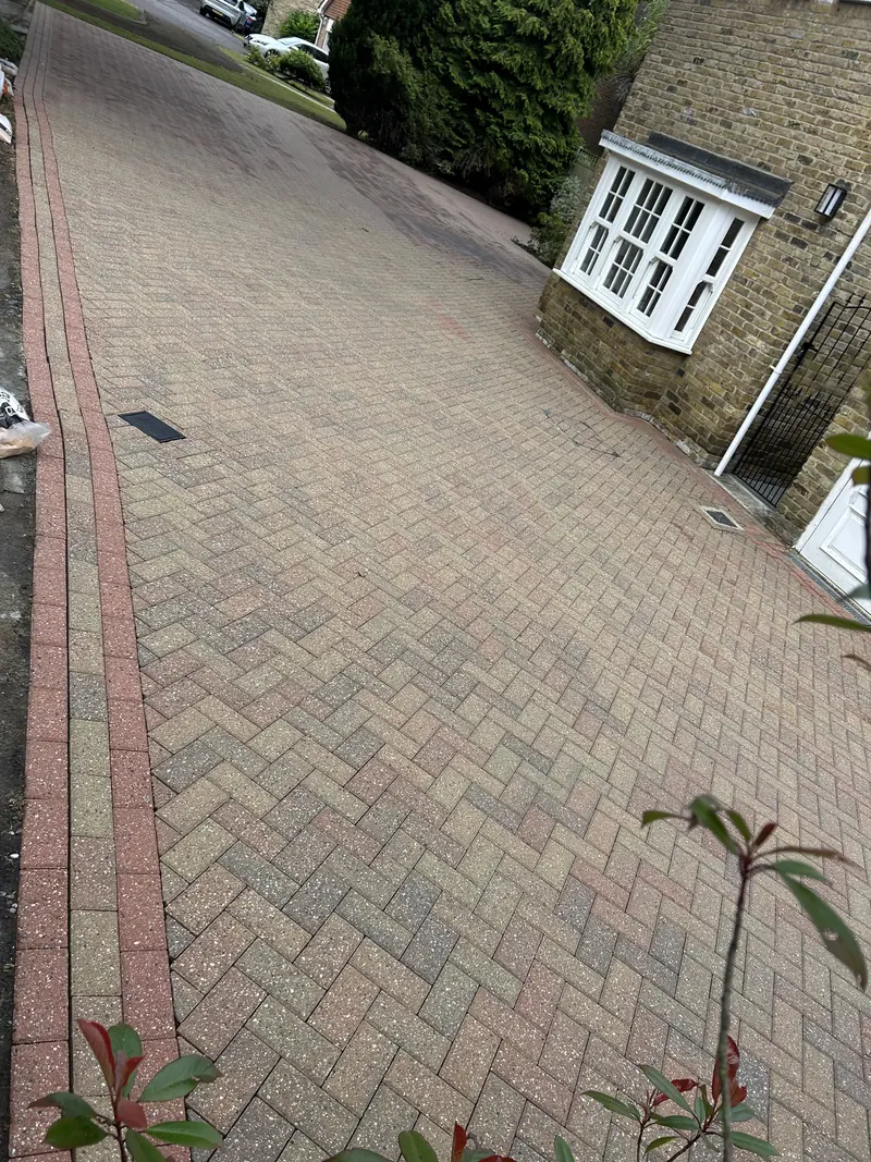 Herringbone block-paved driveway with a red border beside a house