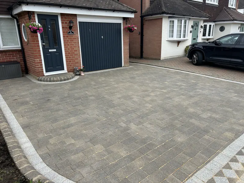 Grey block-paved driveway in front of a garage