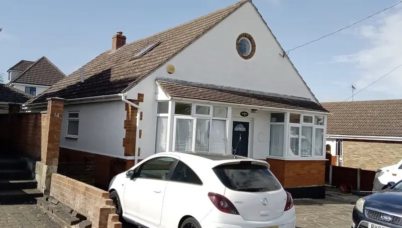 Chalet bungalow with a white car on the drive and tiled roof